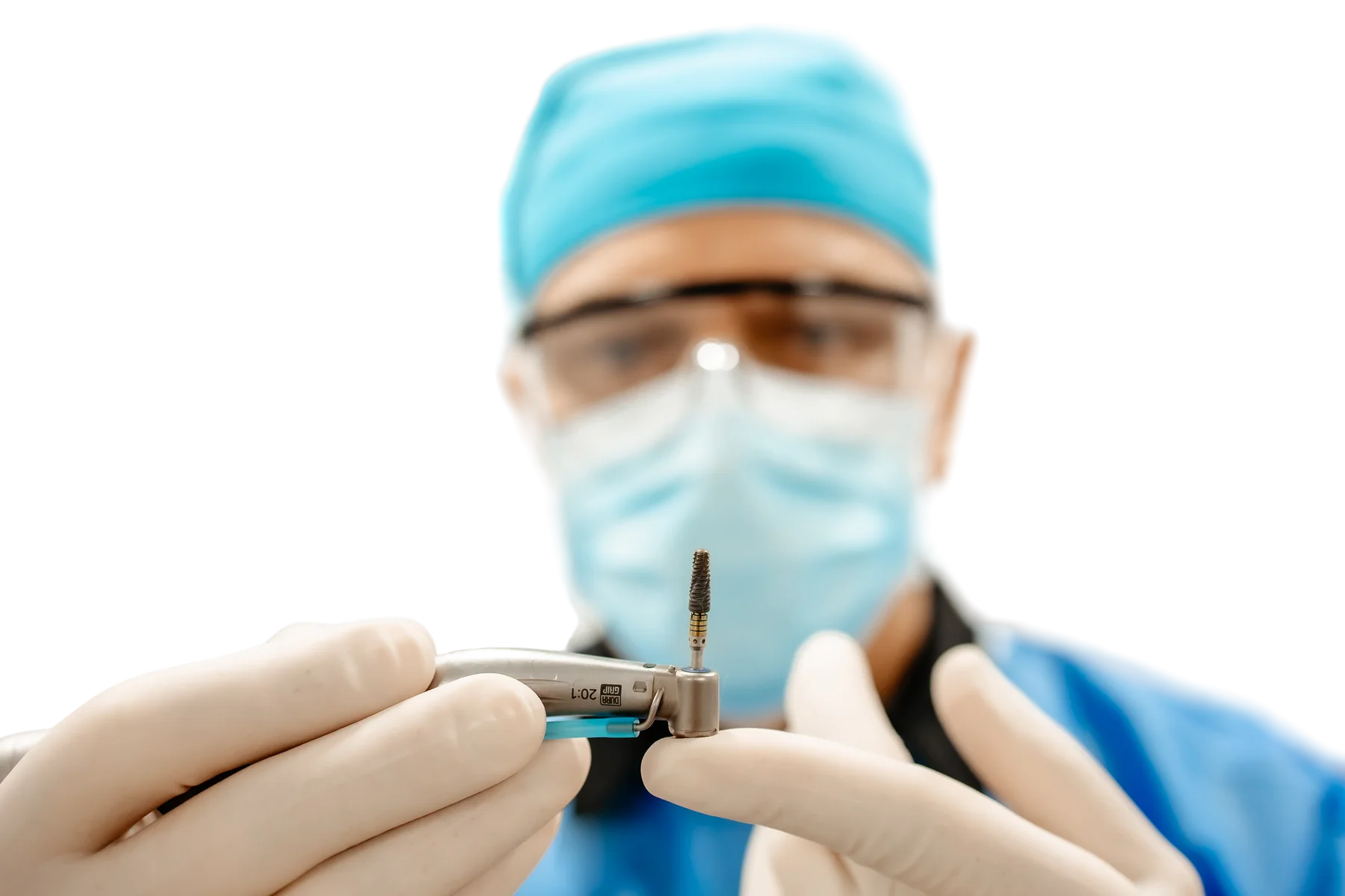 Implant dentar pe instrumentul de inserare, ținut cu mănuși, cu medicul în fundal
