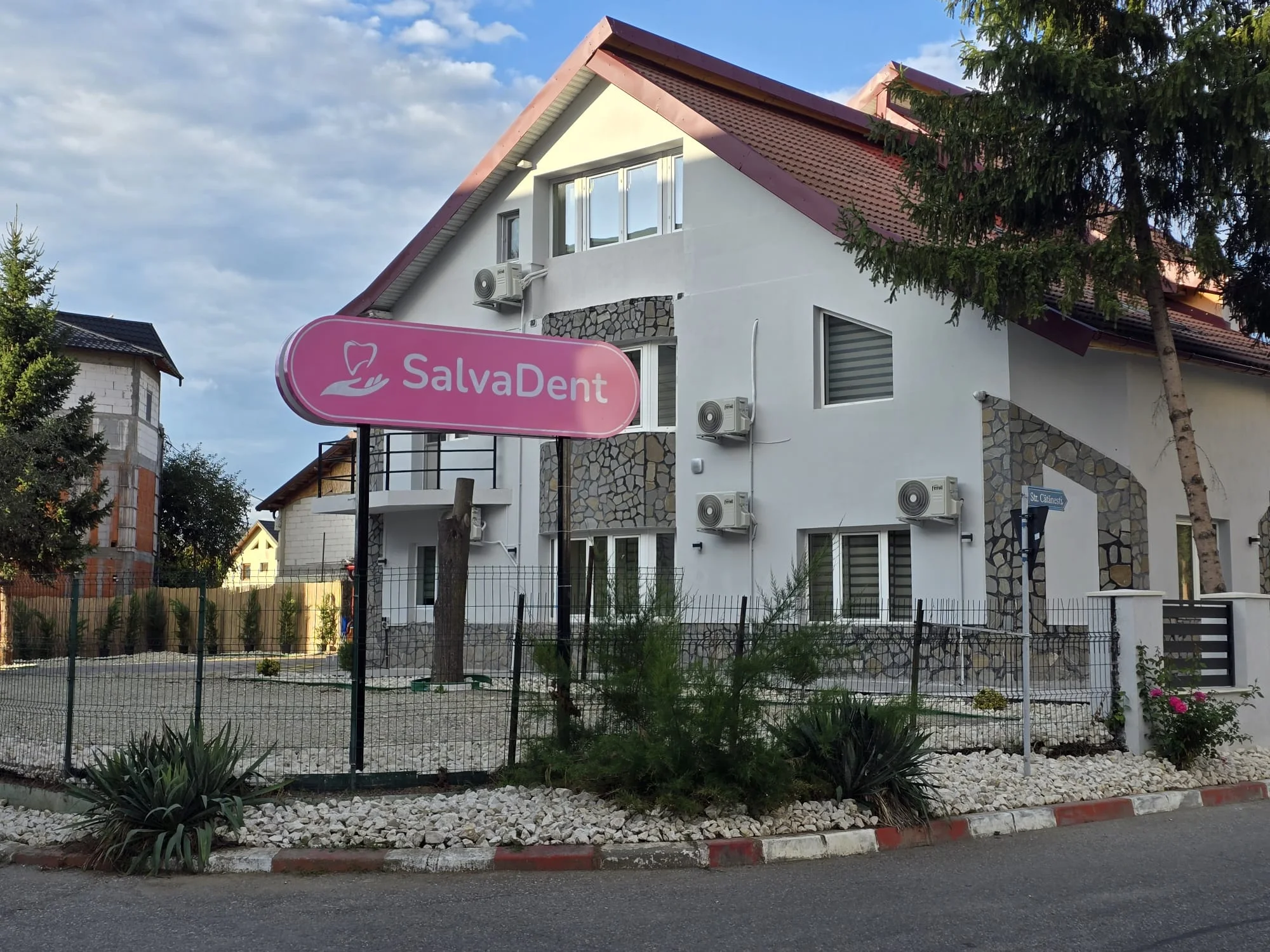Clădirea Clinicii SalvaDent din Mioveni, cu firma roz în față